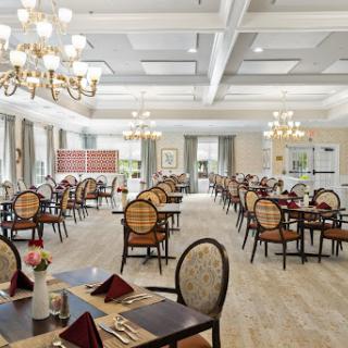 A spacious and elegantly designed dining area featuring classic furniture and stylish chandeliers.