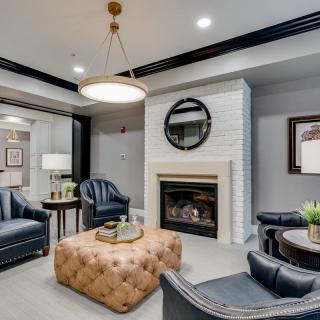 A cozy and stylish living room featuring a fireplace, leather seating, and modern decor.