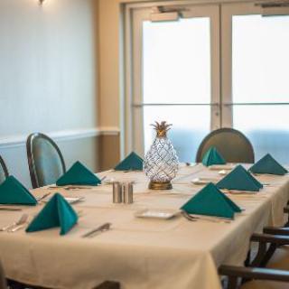 A neatly arranged dining room table with teal napkins and a decorative centerpiece.