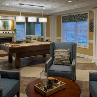 A modern living room featuring comfortable seating and a billiard table.