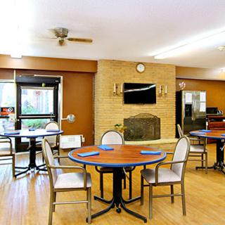 A cozy dining area featuring circular tables and comfortable seating, designed for community meals.