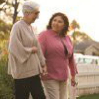 Two people walking and talking together outdoors at sunset.