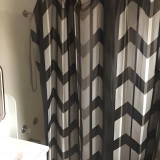 A bathroom with a chevron-patterned shower curtain.