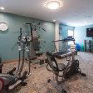 A small indoor gym equipped with various exercise machines and workout gear.