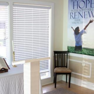 A small chapel room with a podium, chair, and a poster on the wall conveying hope.