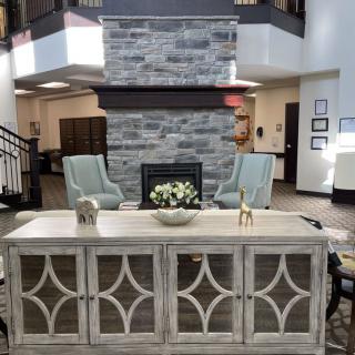 A modern lobby with a central fireplace, comfortable seating, and stylish furniture.