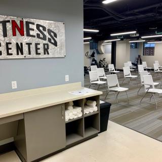 A view of a fitness center interior with rows of chairs and modern decor.