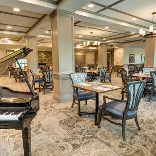 Elegant dining area with a grand piano and stylish interior design.