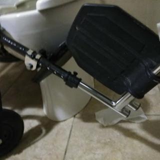 An adjustable footrest positioned beside a toilet to enhance accessibility.