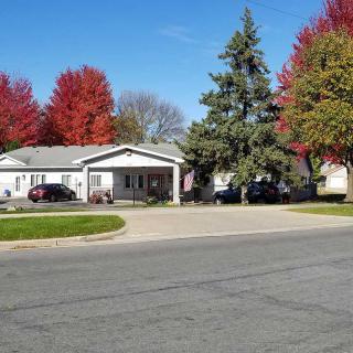 A residential house with a driveway, surrounded by colorful autumn trees.