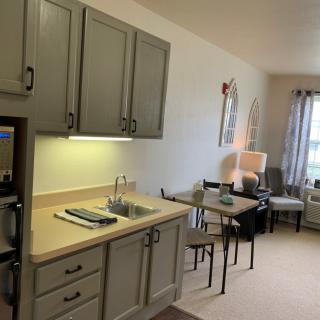 A cozy apartment interior featuring a small kitchen and living area with modern furniture.