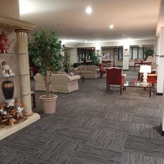 A spacious and inviting lobby area featuring cozy seating, decorative plants, and warm lighting.