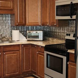 A modern kitchen featuring wooden cabinets and stainless steel appliances.