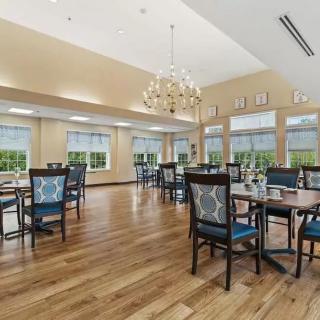A spacious dining area with elegant furniture and a chandelier.