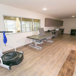 A rehabilitation room equipped with therapy tables and exercise equipment.