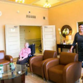 A cozy living room with comfortable seating and two people, one of whom is in a wheelchair.