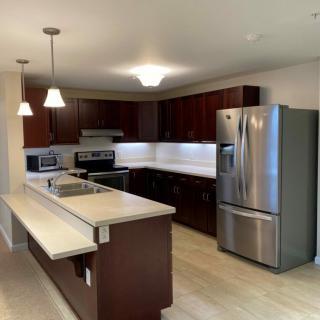 A modern kitchen featuring stainless steel appliances and wooden cabinetry.