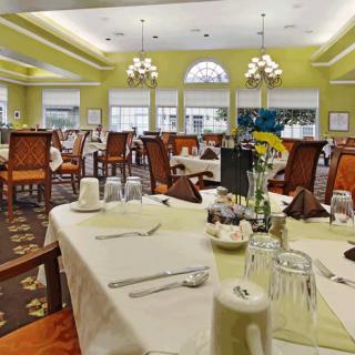 A well-decorated dining room with set tables and elegant chandeliers.