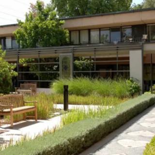 A modern building with a well-maintained garden and outdoor seating area.