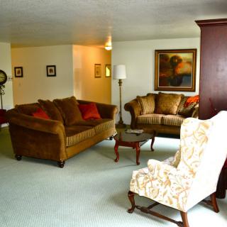 A cozy living room with sofas, an armchair, and a coffee table arranged for comfort and style.