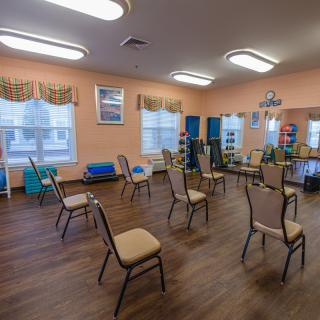 An empty room with chairs arranged in a circle, likely set up for a group activity or class.
