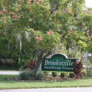 Sign for Brooksville Healthcare Center surrounded by trees.