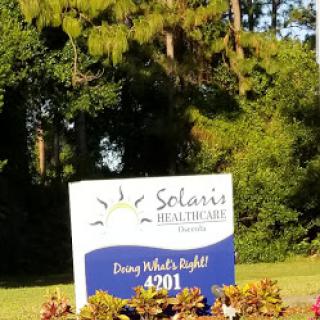 A sign for Solaris Healthcare, promoting the values of community and care.