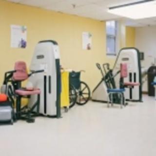 A gym room featuring various exercise machines and fitness equipment.