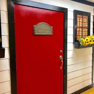 A vibrant red door with decorative elements and a bright window.