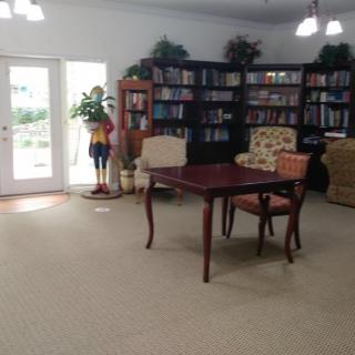 A cozy library space with bookshelves, a table, and chairs.