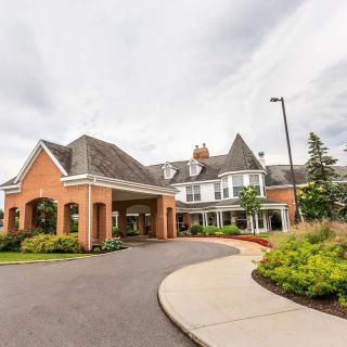 A large, elegant building with a covered entrance and well-maintained landscaping.