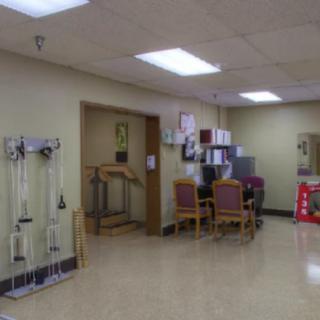 An empty waiting area in a medical facility with chairs and medical equipment.