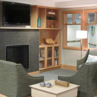 A cozy living room with comfortable seating, a fireplace, and a television.