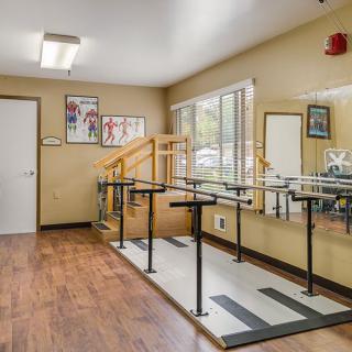 A physical therapy room equipped with parallel bars for rehabilitation exercises.