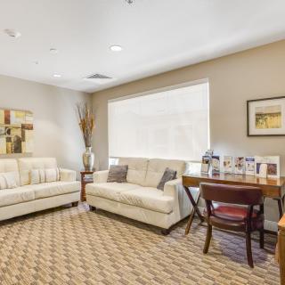 A cozy living room with white sofas, a desk, and stylish decor.