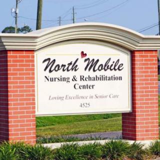 A sign for North Mobile Nursing & Rehabilitation Center surrounded by a brick structure.