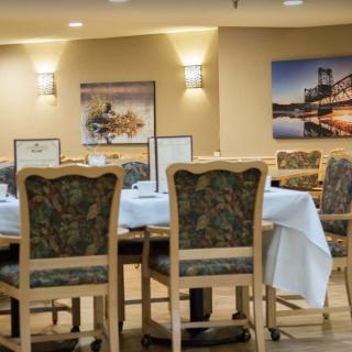 A cozy dining area with elegantly set tables and tasteful artwork on the walls.