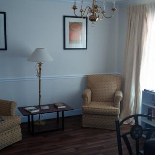 A cozy living room with a sofa, armchair, and elegant decor.