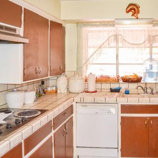 A retro-style kitchen with wooden cabinets and vintage decor.