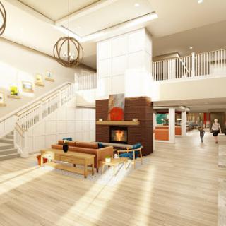 A bright and inviting modern lobby featuring a cozy fireplace and stylish furnishings.
