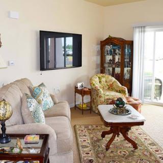 Cozy living room featuring a comfortable sofa, stylish armchair, and modern TV setup.