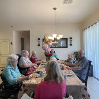 A joyful family gathering around the dinner table, sharing delicious food and good company.