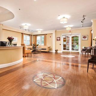A modern lobby with wood flooring, comfortable seating, and stylish lighting.