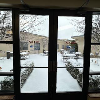 A view of a snow-covered courtyard through glass doors.