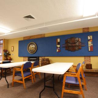 A well-lit meeting room featuring tables, chairs, and decorative wall art.