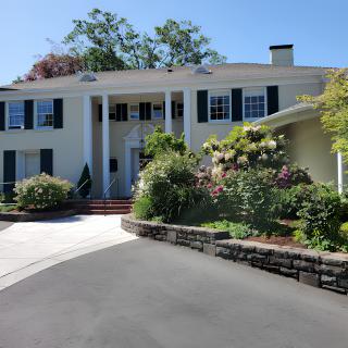 A beautiful residential house with a well-maintained garden and a curved driveway.