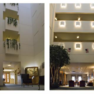 A spacious hotel lobby features an atrium with multiple balconies, decorative plants, and warm lighting.