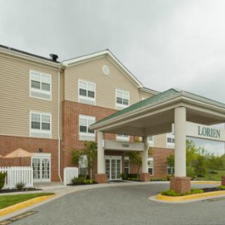 A hotel building with a covered entrance and brick facade.