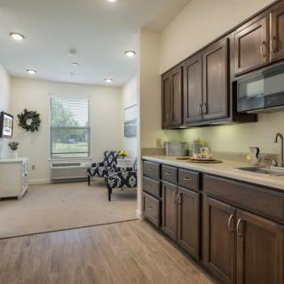 A modern open-plan kitchen and living area featuring wood cabinets and contemporary furniture.