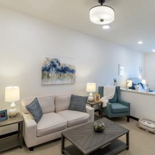 A modern living room with a cozy sofa, stylish coffee table, and elegant artwork on the wall.